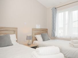 A bedroom with two beds and a nightstand at 2 Summerleaze in Bude