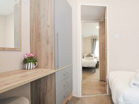 A bedroom with a dresser and a view of another room at 2 Summerleaze in Bude