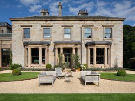 A house with garden seating and planters at The Country House Cumbria Castle Carrock