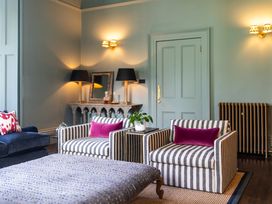 A living room with armchairs and a coffee table at The Country House Cumbria Castle Carrock