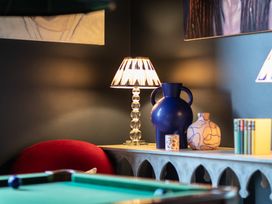 A lamp and vases on a shelf in a game room at The Country House Cumbria Castle Carrock