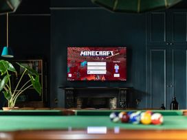 A game room with a television displaying Minecraft at The Country House Cumbria Castle Carrock