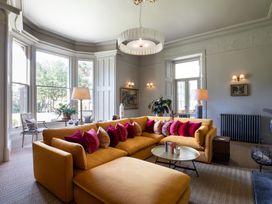A living room with a yellow sofa and coffee table at The Country House Cumbria in Castle Carrock