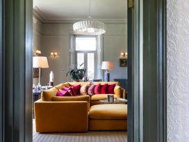 A living room with a yellow sofa and a lamp at The Country House Cumbria Castle Carrock