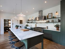 A kitchen with an island and stools at The Country House Cumbria Castle Carrock