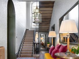 A hallway with stairs, lamps, and a mirror at The Country House Cumbria in Castle Carrock