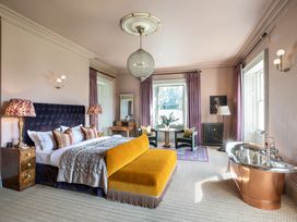 A bedroom with a bed, sofa, and a bathtub at The Country House Cumbria Castle Carrock