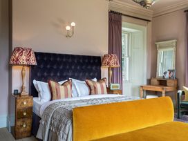 A bedroom with a bed and dressing table at The Country House Cumbria Castle Carrock