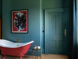 A bathroom with a bathtub near a door at The Country House Cumbria in Castle Carrock