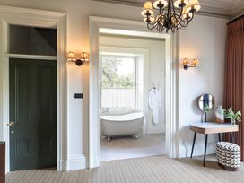 A bathroom with a bathtub and mirror at The Country House Cumbria in Castle Carrock