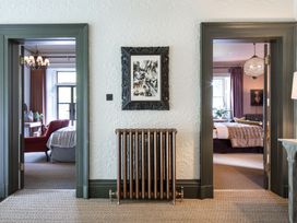 A hallway with a radiator and doorways at The Country House Cumbria Castle Carrock