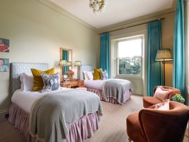 A bedroom with two beds and a chair at The Country House Cumbria Castle Carrock