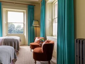 A bedroom with two beds and a seating area at The Country House Cumbria in Castle Carrock