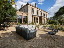 A garden with a sofa and chairs at The Country House Cumbria Castle Carrock