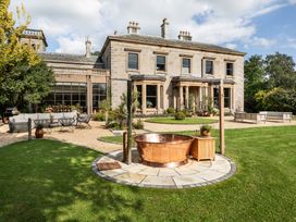A garden with a copper bathtub and outdoor seating at The Country House Cumbria Castle Carrock