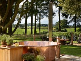 A garden with a hot tub and outdoor shower at The Country House Cumbria Castle Carrock