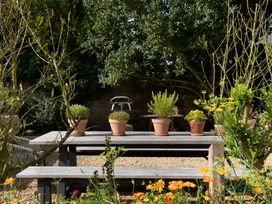 A garden with a table and flower pots at The Country House Cumbria, Castle Carrock