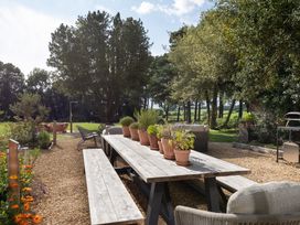 A garden with a table and chairs surrounded by potted plants at The Country House Cumbria Castle Carrock