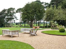 A garden with outdoor seating and a gravel path at The Country House Cumbria Castle Carrock