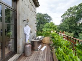 An outdoor bathroom with a bathtub and plants at The Country House Cumbria Castle Carrock