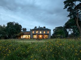 A house with windows and grass at The Country House Cumbria Castle Carrock