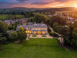A large house with a garden and patio area at The Country House Cumbria Castle Carrock