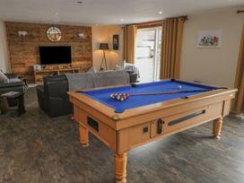 A game room with a pool table and sofa at Pompian Lodge in Leyland