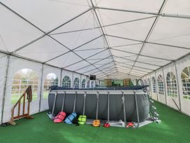 A swimming pool and life jackets in a canopy tent at Pompian Lodge Bretherton near Tarleton