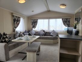 A living room with a sofa and dining area at 123 Elms in 