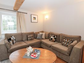A living room with a sofa and coffee table at Secret Garden Cottage in Ciliau Aeron near Aberaeron
