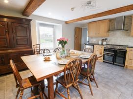 A dining room with a wooden table and sideboard at Secret Garden Cottage, Ciliau Aeron near Aberaeron