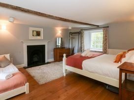 A bedroom with two beds and a fireplace at Secret Garden Cottage in Ciliau Aeron near Aberaeron