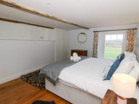 A bedroom with a bed and dresser at Secret Garden Cottage in Ciliau Aeron near Aberaeron