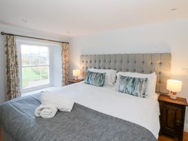 A bedroom with a large bed and bedside tables at Secret Garden Cottage in Ciliau Aeron near Aberaeron