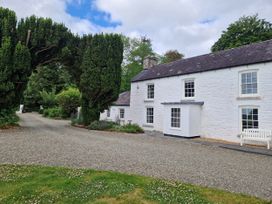 A house with trees and a gravel path at Secret Garden Cottage Ciliau Aeron near Aberaeron