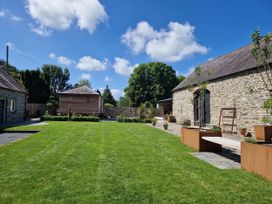 A garden with grass and buildings at Secret Garden Cottage near Aberaeron