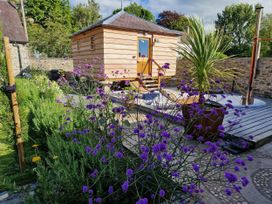 A garden with flowers and a wooden structure at Secret Garden Cottage Ciliau Aeron near Aberaeron