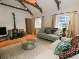 A living room with a fireplace and a coffee table at Secret Garden Cottage in Ciliau Aeron near Aberaeron