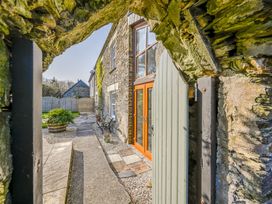 An outdoor pathway with a stone wall and door at The Old Farm House near Pelynt