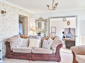 A living room with a sofa and a mirror at The Old Farm House near Pelynt