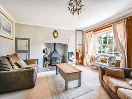 A living room with a fireplace and coffee table at The Old Farm House near Pelynt