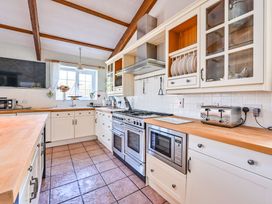 A kitchen with cabinets and appliances at The Old Farm House near Pelynt