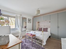 A bedroom with a bed, wardrobe, and table at The Old Farm House near Pelynt