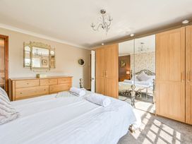 A bedroom with a double bed and wooden furniture at The Old Farm House near Pelynt