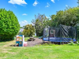 A garden with a trampoline and playhouse at The Old Farm House near Pelynt