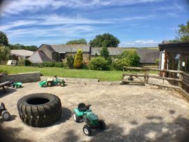 A yard with toy tractors and a tire at The Old Farm House near Pelynt