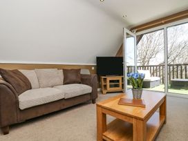 A living room with a sofa, coffee table, and television at Valley Lodge 61 in Callington