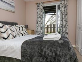 A bedroom with a bed and curtains at Valley Lodge 61 Callington