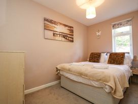 A bedroom with a bed and window at Valley Lodge 61 in Callington
