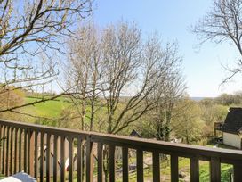 A view from a balcony showing trees and a field at Valley Lodge 61 Callington